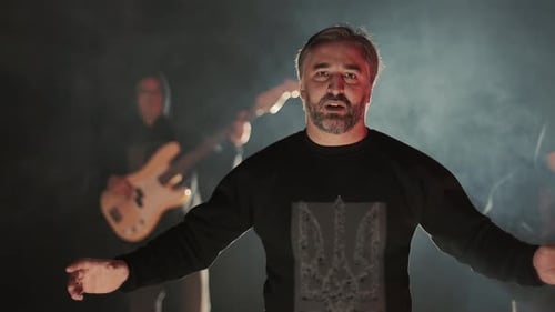 Singer Performing with Band on Smoky Stage