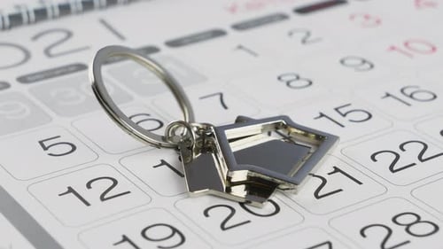 Key with a House Shaped Keychain and Wall Calendar