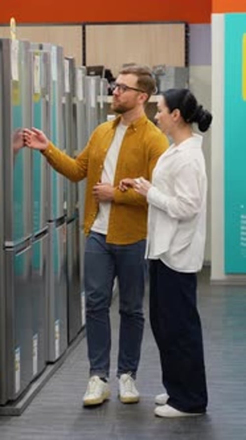 Young Couple is Viewing Fridge in Home Appliances Store Vertical Video