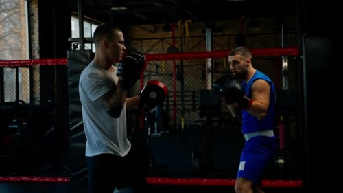 Boxer Practices His Punches with His Coach in the Boxing Gym