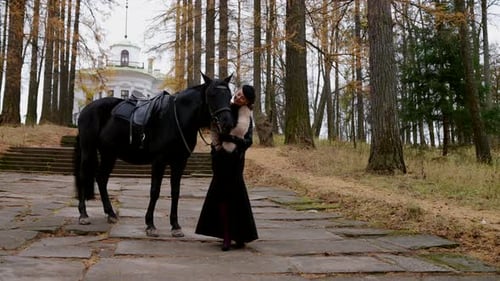 Femme aristocrate vêtue d'une belle robe longue vintage et d'un cheval pur-sang à Royal Park
