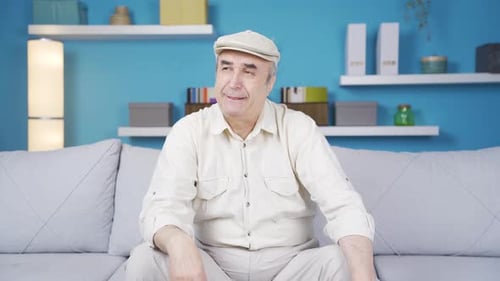 Sad and depressed old man crying at home.