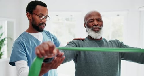 Physical Therapist Helping Senior with Resistance Band Exercise