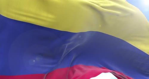 Realistic Colombian National Flag Waving in Bright Blue Sky