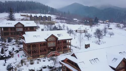 Aerial of Wooden Cottages in Mountain Village Surrounded with Coniferous Forest Drone View of