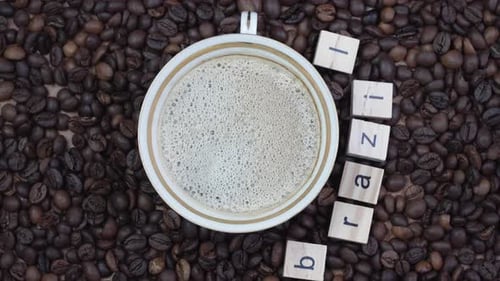 Top View of a Cup of Coffee on a Background of Coffee Beans with the Inscription Brazil