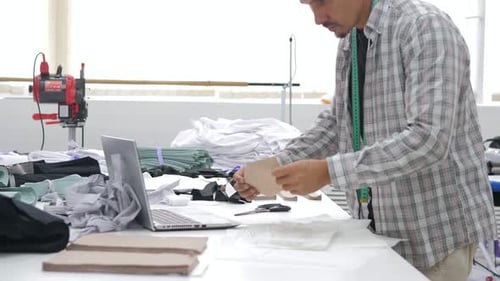 Male Fashion Designer Searching of Inspiration Makes Fashion Sketch in Studio Atelier Has a