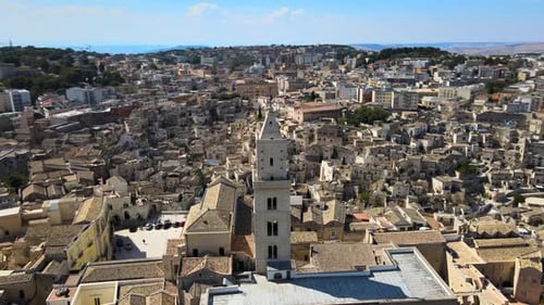 Aerial drone shot around a tower of a cathedral in Matera, Italy. The oldest ancient city in Europe.