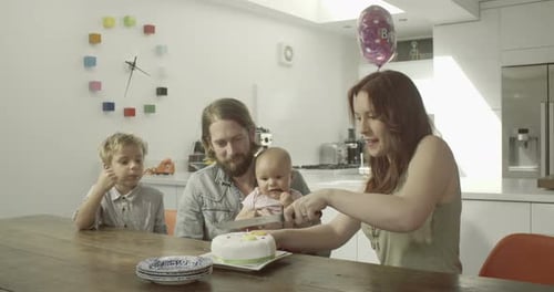 Family celebrates baby's first birthday in modern kitchen