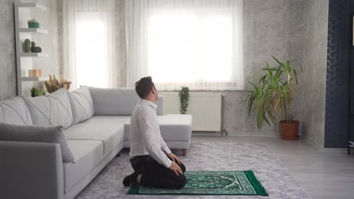 Man Praying on Rug Inside Bright Living Room