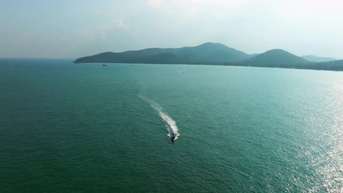Longtail Boat Sailing Across Crystal Waters With Lush Green Thai Islands