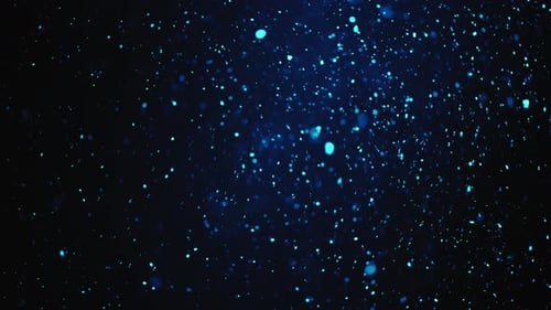 Blaue Glitzerpartikel fallen in Lichtstrahlen