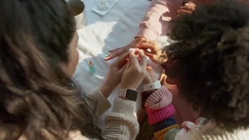O cliente está estendendo a mão, a manicure está limpando e aplicando esmalte de menta para manicure na mesa