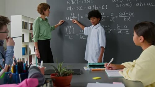 Teacher explains math problems to students in classroom