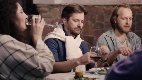 Friends Enjoying Dinner and Wine Together at Restaurant