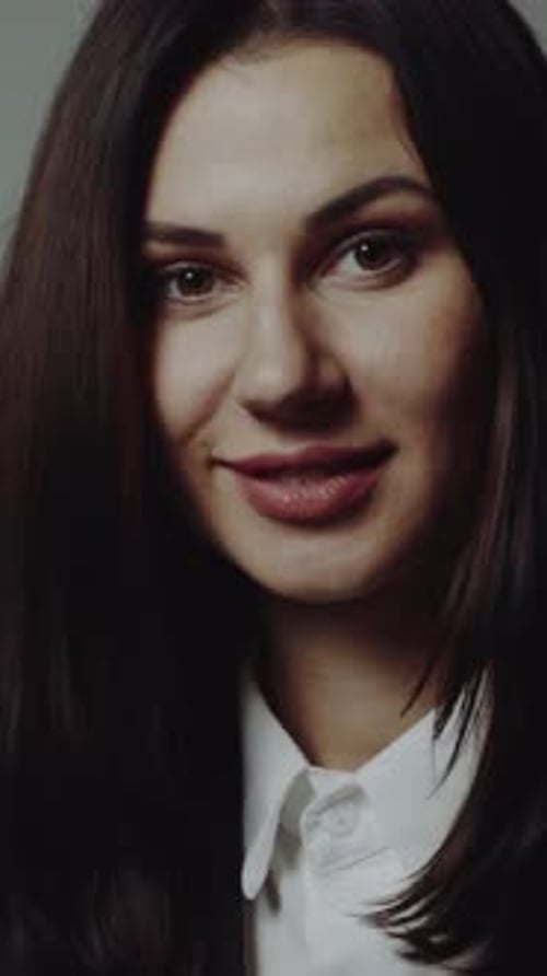 Portrait of a young beautiful brunette with a beautiful make up Vertical video
