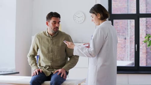 Man Talking to Doctor in a Medical Clinic