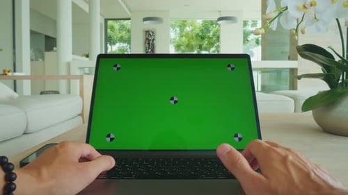 POV Green Screen Laptop on Desk As Man Works Indoors in Modern Interior Green Screen Laptop Concept