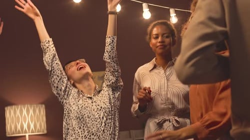 Friends Dancing and Celebrating at an Evening Party