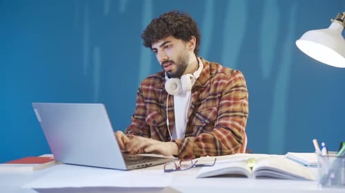 The unsuccessful young man gets angry and bored by what he sees on the laptop screen.