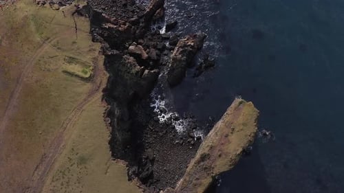 Steep cliffs at shore of Iceland shaped by years of sea erosion, aerial