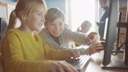 Elementary School Computer Science Classroom: Portrait of Smart Girl and Boy Talking while using Pe