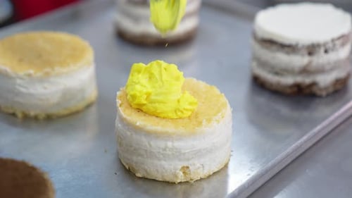 Cake Preparation with Yellow Frosting on Top
