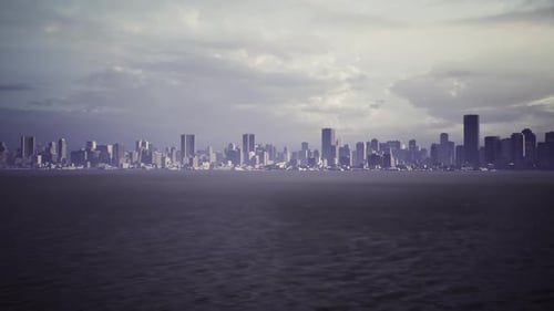 A Panoramic View of a City Skyline Silhouetted Against a Cloudy Sky