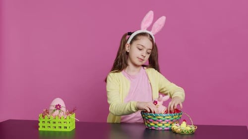 Erschöpftes kleines Kind dekoriert festliches Ornament für die Feier am Ostersonntag