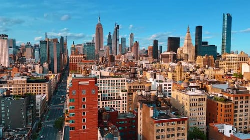 Multiple water tanks on the roofs of New York buildings. Famous skyscrapers tower above
