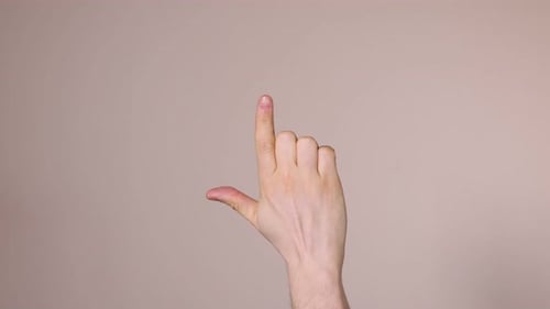 Man pointing at something on beige background, closeup