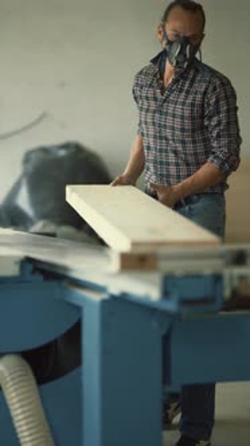 Carpenter with Respirator Mask Working Wood