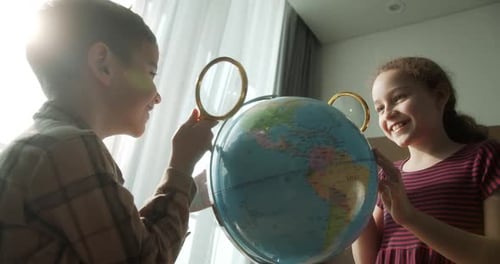 Children is Studying While Sitting at Home in Rays Sunset in Room