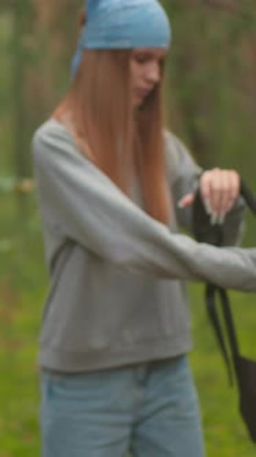 Siblings Walking Through Peaceful Forest and Pausing to Open Backpacks