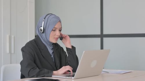 Muslim Businesswoman with Headset Talking with Customers Online in Call Centre