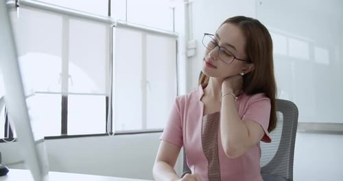Office woman self-massaging neck and shoulders after long computer