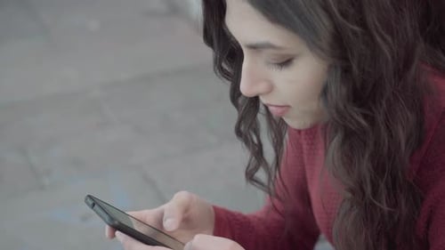 Girl texting near brick wall static close up