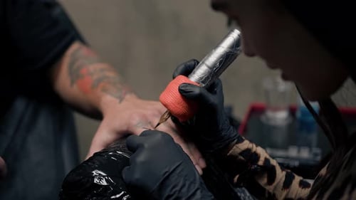 Close-up - a needle penetrates the skin, tattoo, tattoo studio