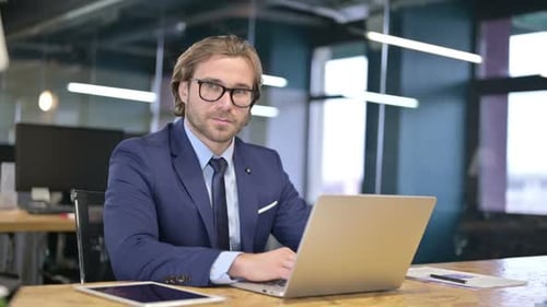 Adult Man Typing on Laptop Gives Thumbs Up