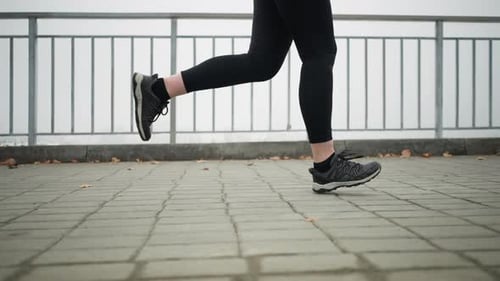 Legs and Feet of Person Running in Urban Setting
