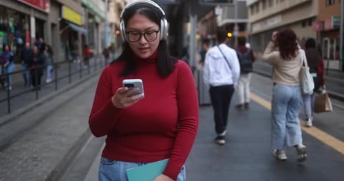Woman Uses Phone on Busy City Street