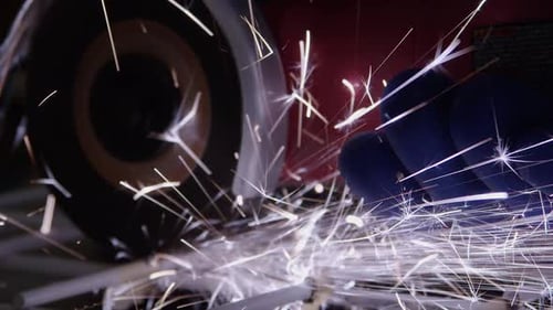 Closeup in workshop: Sparks fly from cutting disc cutting steel rack