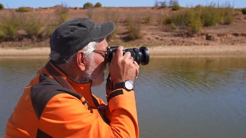 Senior Photographer Takes Pictures By Calm Lakeside