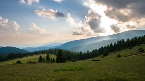 Beautiful moving clouds over the tree-covered mountain slopes