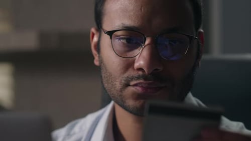 Man Using Laptop with Credit Card Close-Up