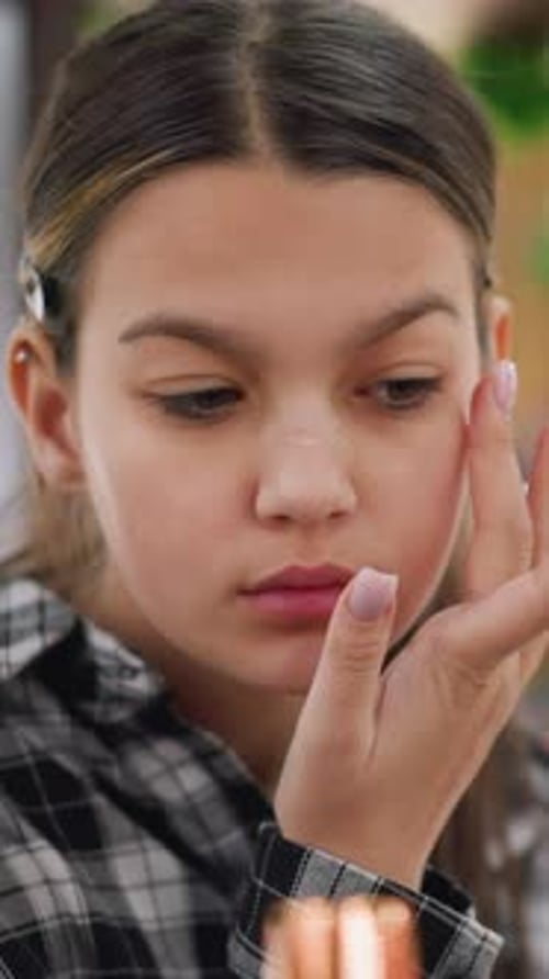 Closeup View of Young Girl Applying Serum Makeup on Face for Skincare Routine