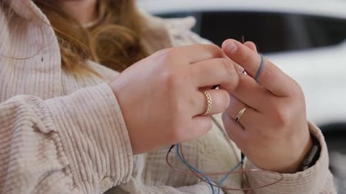 Close Up of Hands Knitting with Blue Yarn
