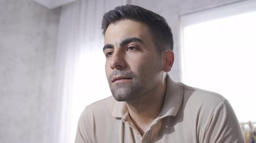 Thoughtful Young Man Indoors Looking to Side