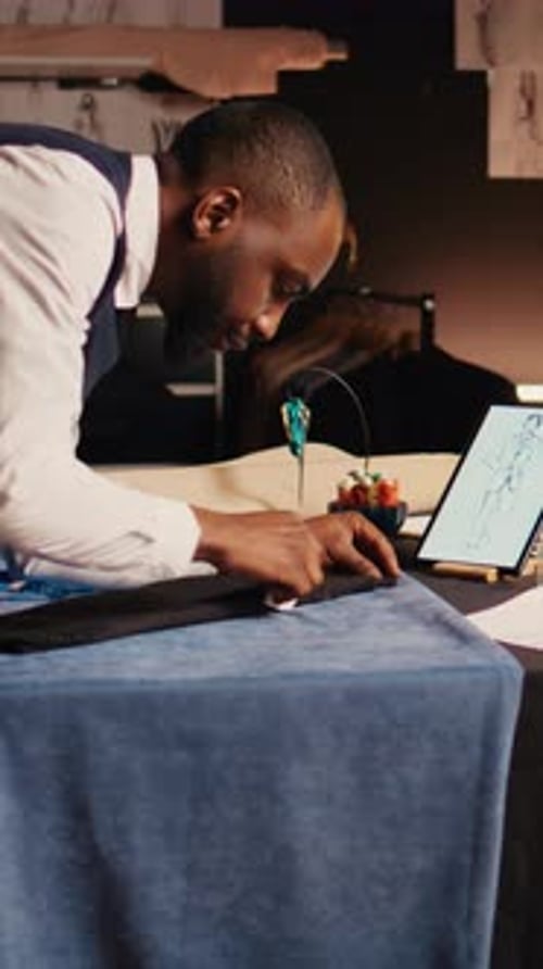 Focused Tailor Measuring Fabric in Fashion Studio