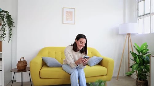Woman Using Phone While Relaxing on Couch